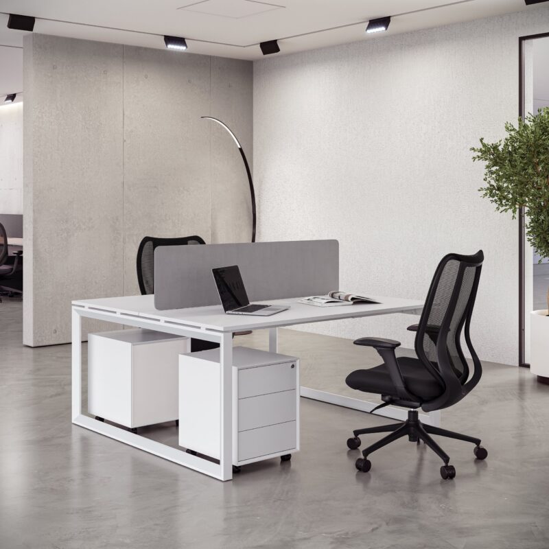 Minimalist white shared desk setup with a gray divider, mobile pedestals, and a black mesh Ergonomic Chair.