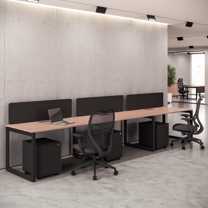 Contemporary light wood four-person Office Table with black frame, acoustic dividers, and mesh task chairs.